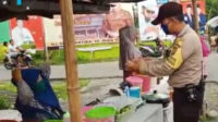 Bhabinkamtibmas Polsek Seginim, Bripka Surahman Budi Utama mengimbau para pedagang dan pengunjung Pasar Ramadhan di Kelurahan Pasar Baru