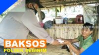 Aipda Susilo menyerahkan bantuan makan siang kepada salah satu warga Seginim