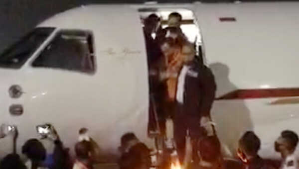 Joko Tjandra menuruni tangga pesawat dituntun anggota Bareskrim Polri setiba di Bandara Halim Perdanakusuma, Kamis malam