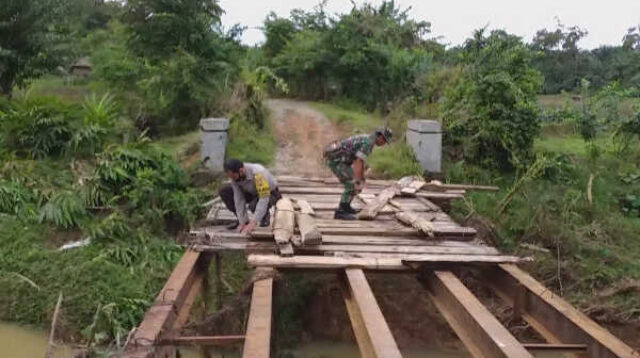 Babinsa Koramil Manna Sertu I Made bersama Bhabinkamtibmas Polsek Manna Bripka Suharno bahu-membahu melaksanakan perbaikan awal pada jembatan yang rusak diterjang banjir