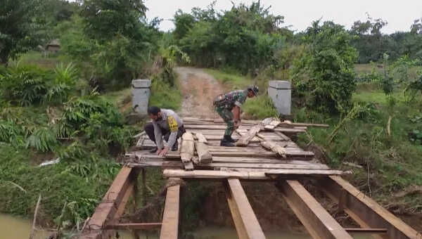 Babinsa Koramil Manna Sertu I Made bersama Bhabinkamtibmas Polsek Manna Bripka Suharno bahu-membahu melaksanakan perbaikan awal pada jembatan yang rusak diterjang banjir