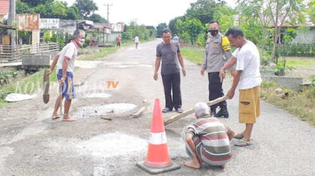 Gotong royong warga Desa Banding Agung menambal jalan raya demi keselamatan pengguna jalan